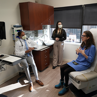 three healthcare professionals talking in a healthcare office